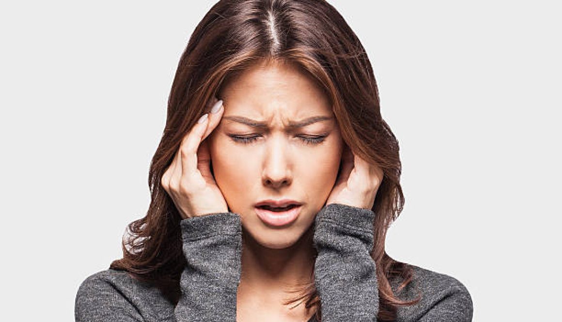 Young woman having headache and holding hands on temples